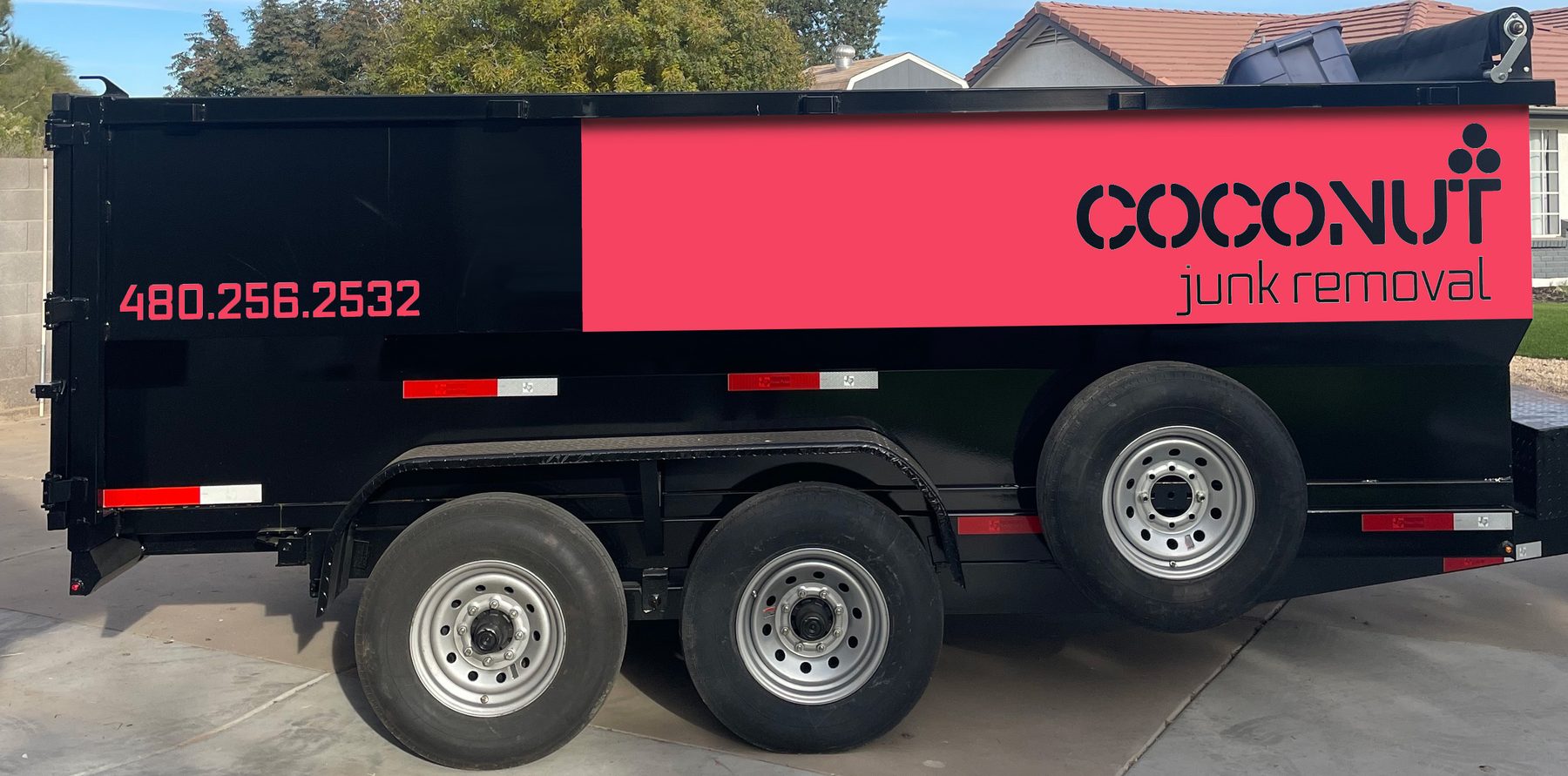 Coconut Junk Removal's black and coral wrapped dump trailer